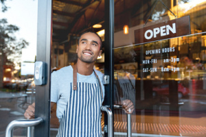 Cafe owner holding door open